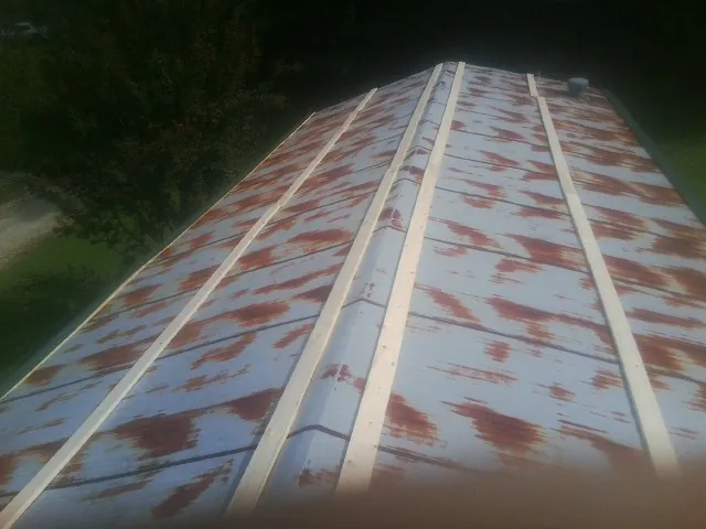 Rusted metal roof panels with new wood purlins before replacement — Storm Damage Roof Repair in Maben by Roofing Brothers