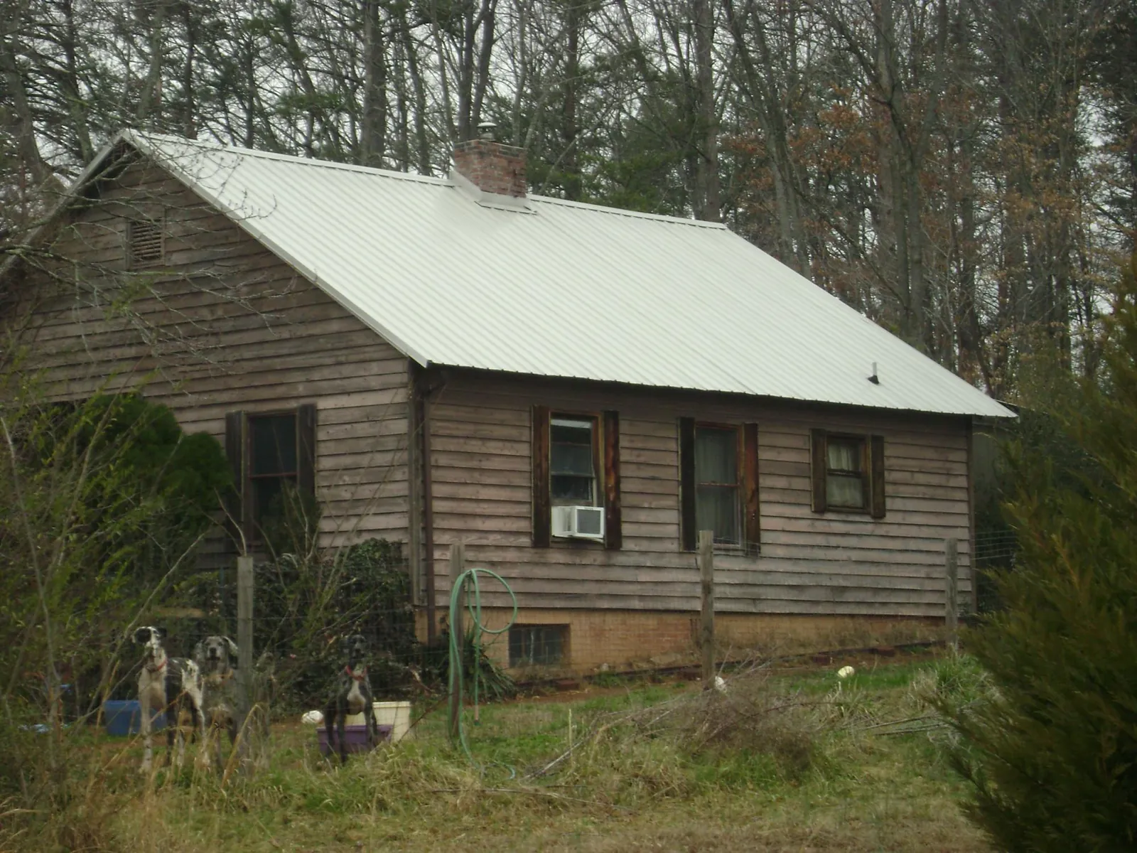 White metal roof on an old wood sided farmhouse, from a Metal Roof Installation job in Maben
